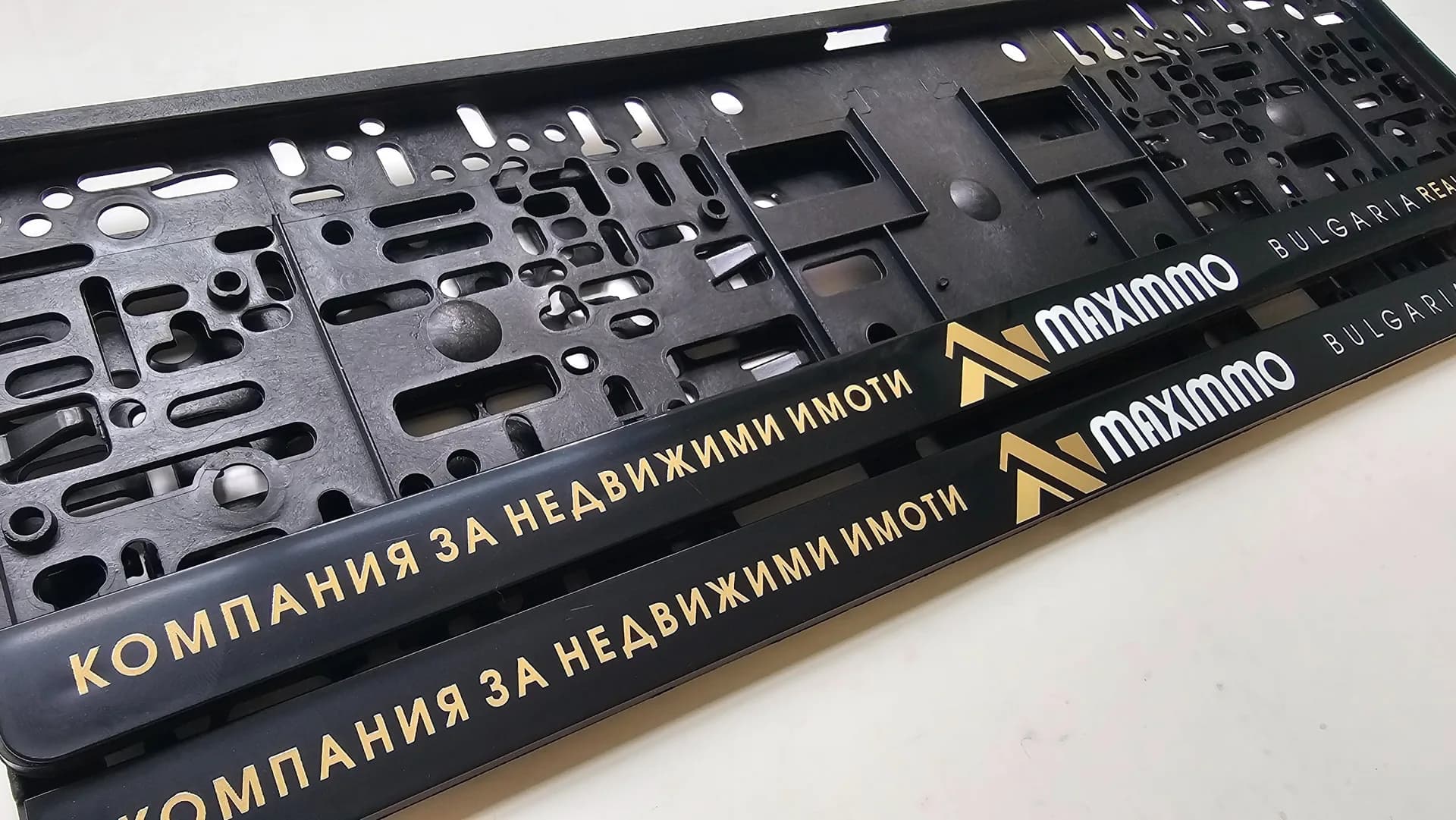 Advertising license plate frame with the text Maximmo real estate — personalized UV print for business