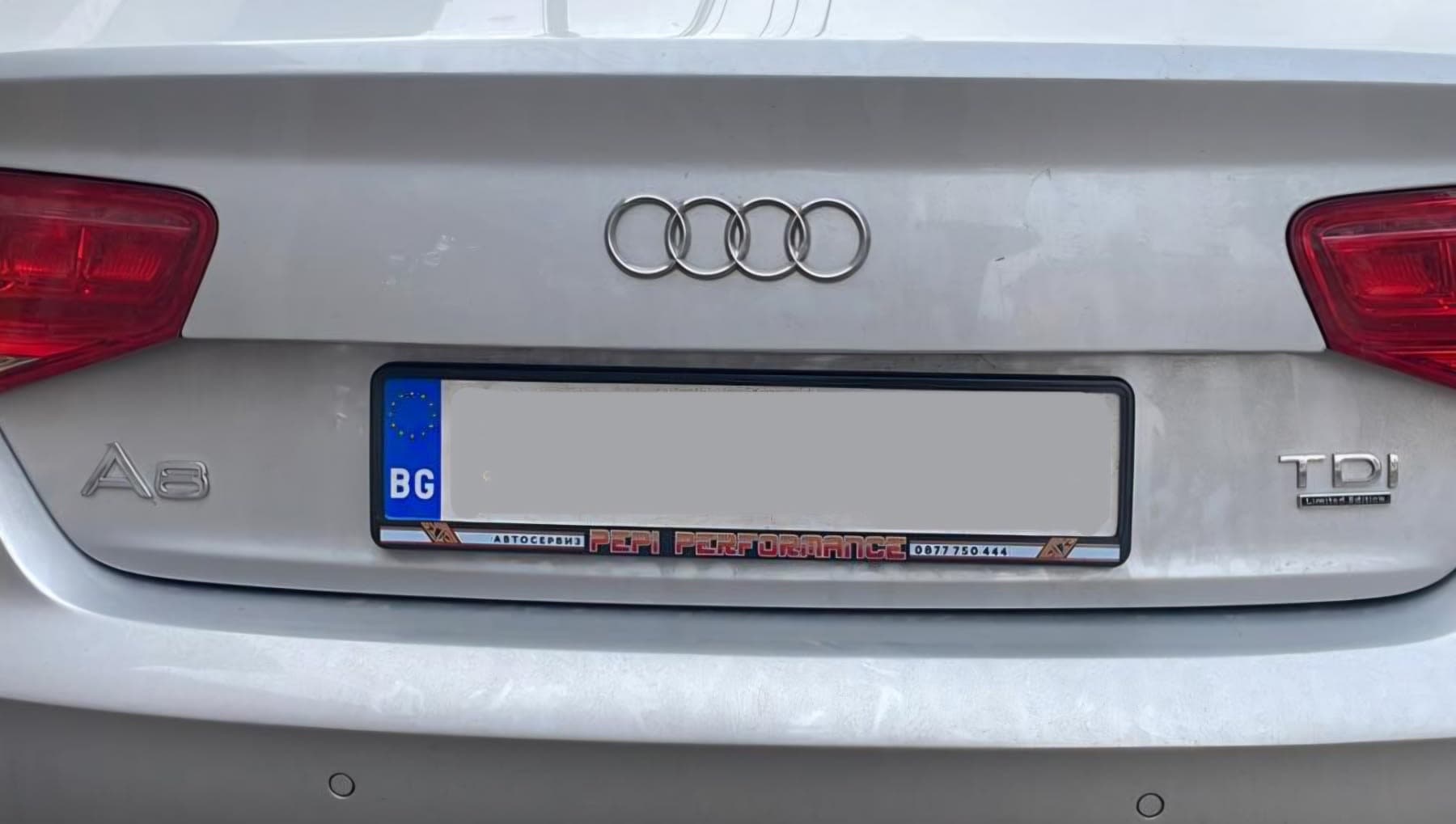 ramă de număr publicitară de service auto montată pe un Audi A8 — ramă de număr de firmă